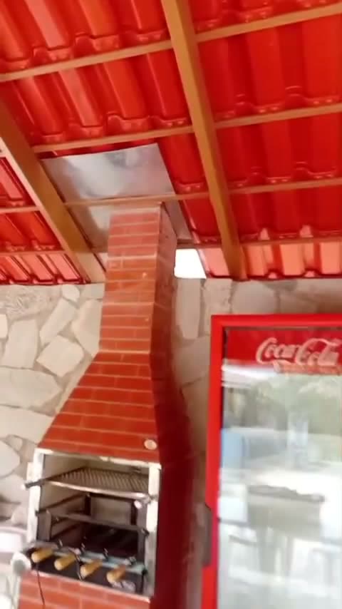 Churrasqueira de tijolo em área de lazer com saída de fumaça